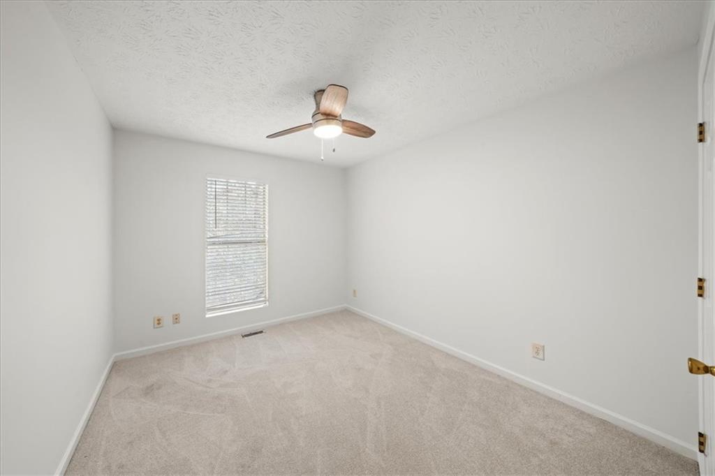 2814 Norfair Loop Lithonia, GA 30038 - Photo 12 of 18 an empty room with windows and chandelier fan