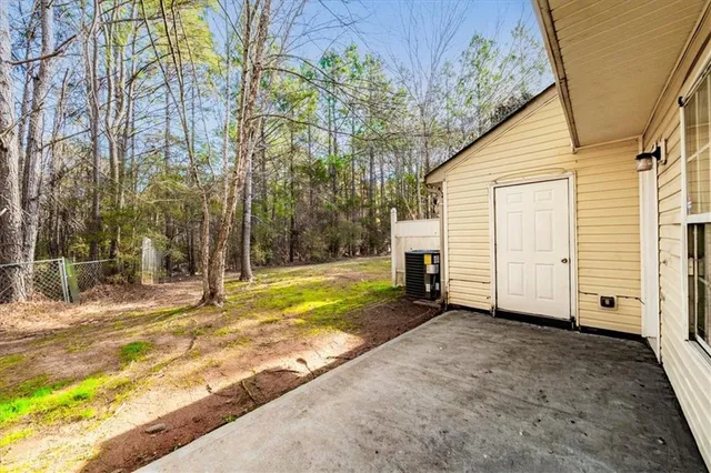 a view of a house with backyard and trees