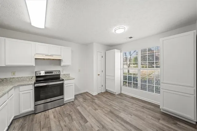a kitchen with granite countertop a stove and a refrigerator