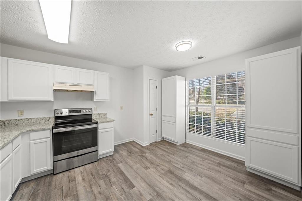 2814 Norfair Loop Lithonia, GA 30038 - Photo 6 of 18 a kitchen with granite countertop a stove and a refrigerator