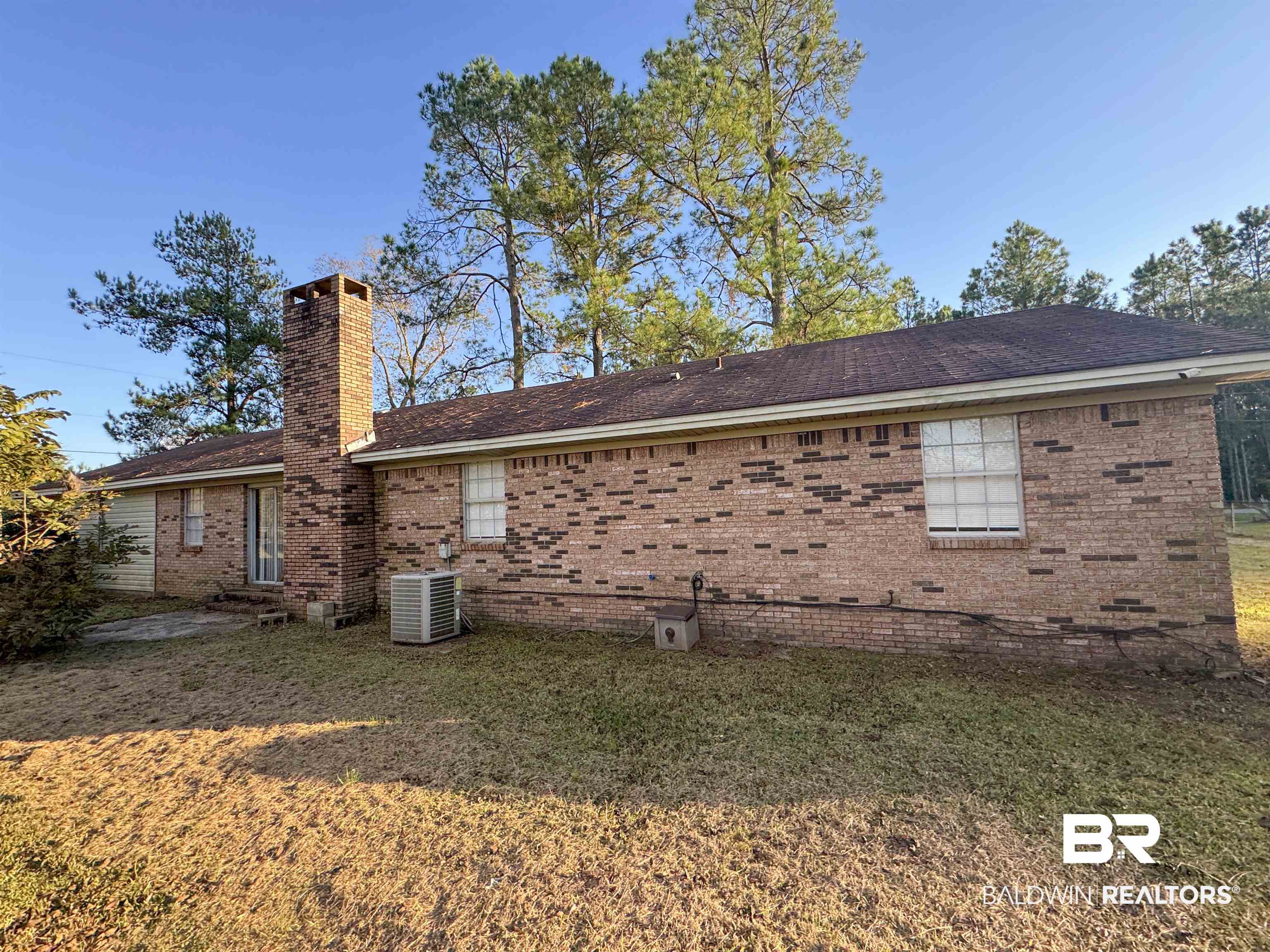 1227 Northgate Drive Atmore, AL 36502 - Photo 14 of 14 Back of property featuring a chimney, a yard, brick siding, and a shingled roof