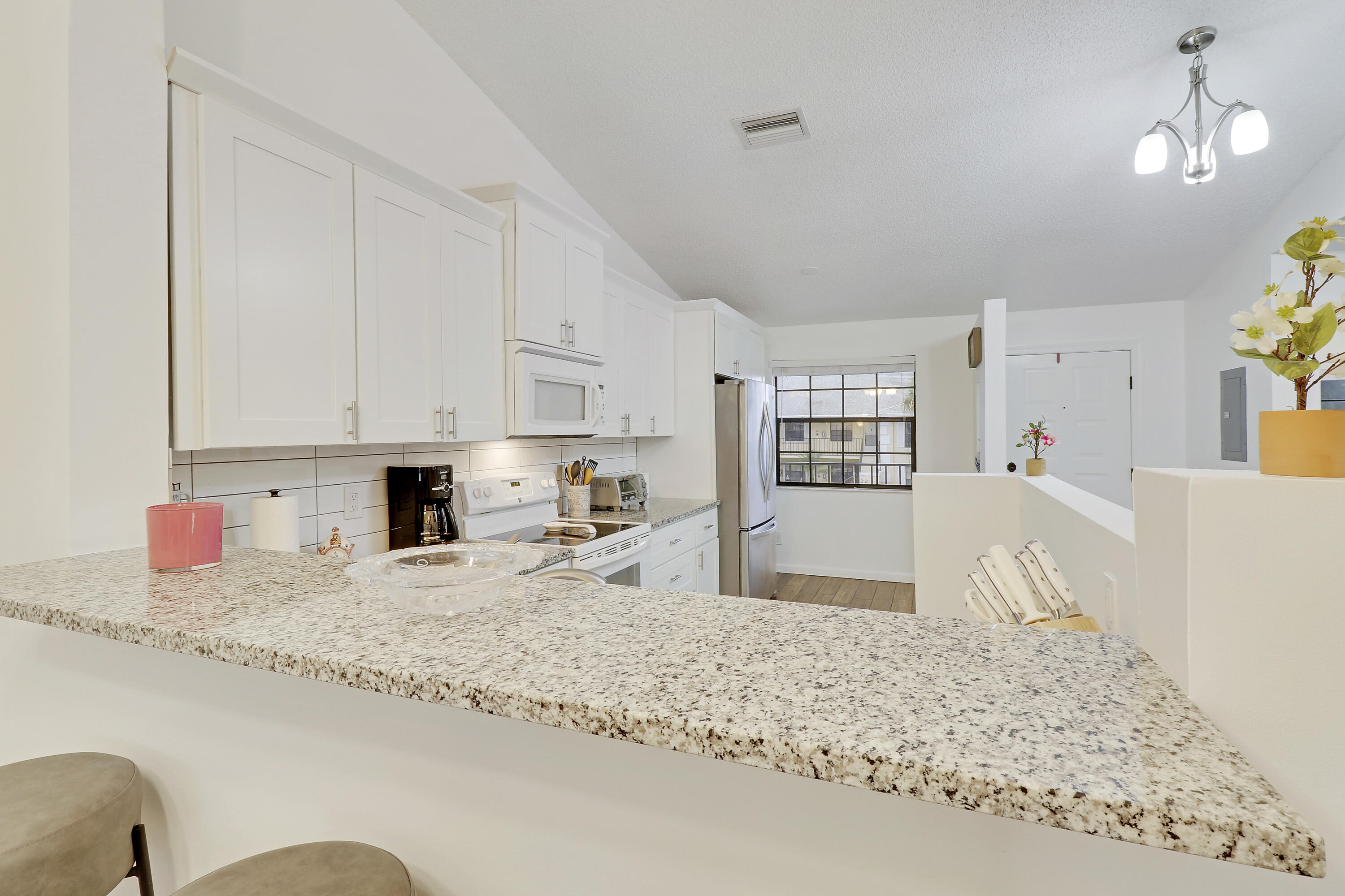 1112 Keystone Drive, Unit A Jupiter, FL 33458 - Photo 13 of 41 a large kitchen with granite countertop a sink white cabinets and a granite counter tops