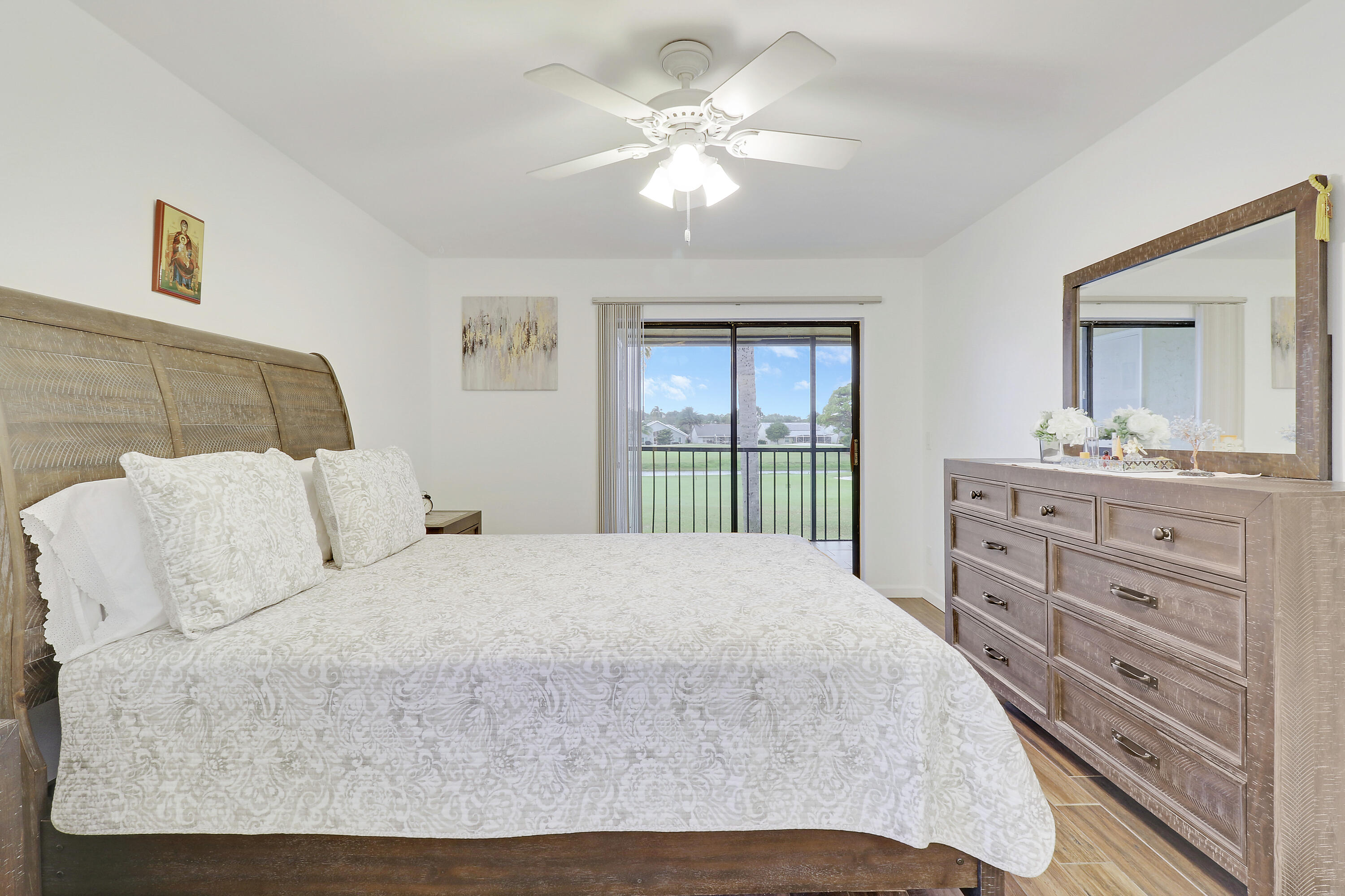 1112 Keystone Drive, Unit A Jupiter, FL 33458 - Photo 19 of 41 a bedroom with a large bed and a chandelier