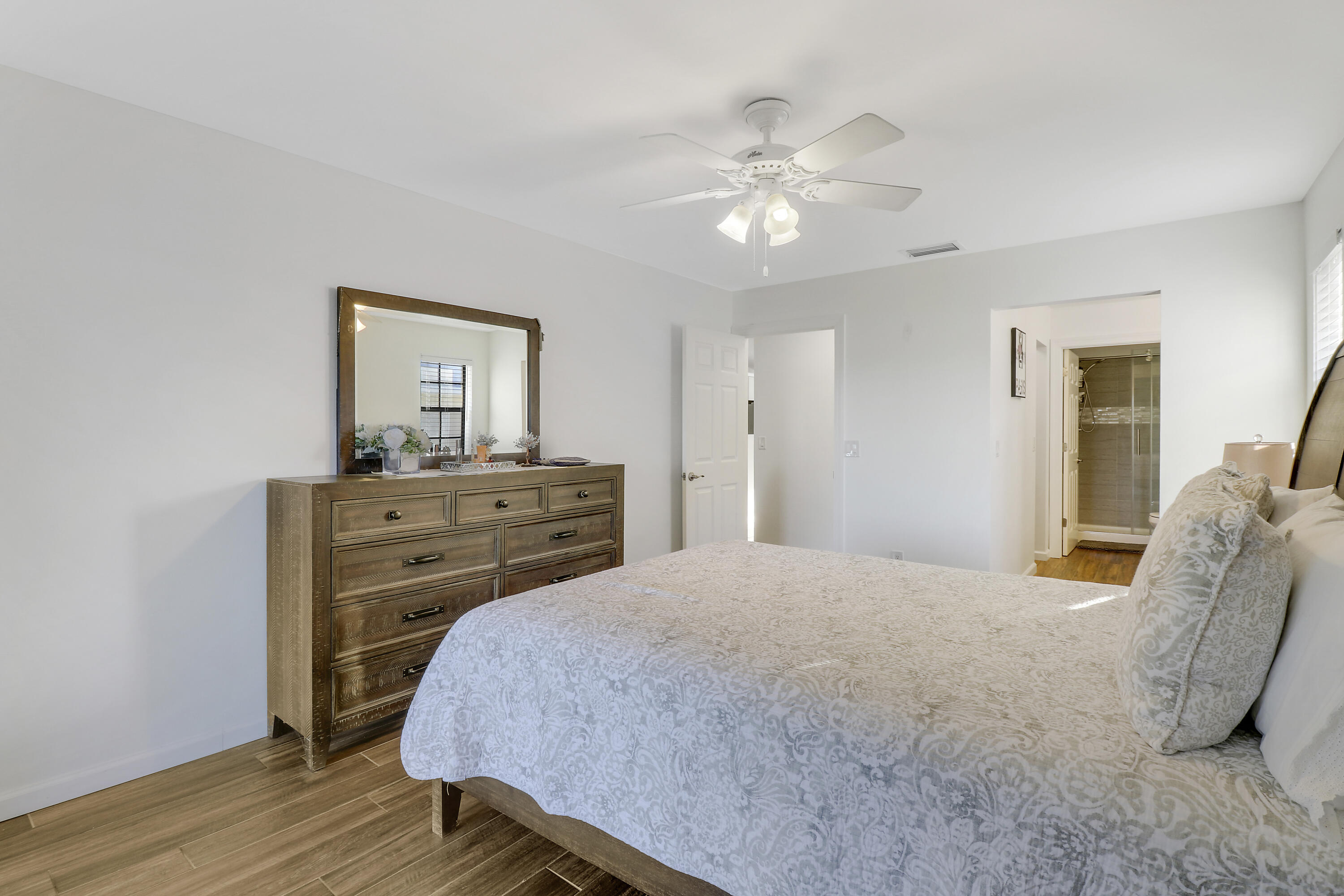 1112 Keystone Drive, Unit A Jupiter, FL 33458 - Photo 20 of 41 a bedroom with a bed and wooden floor