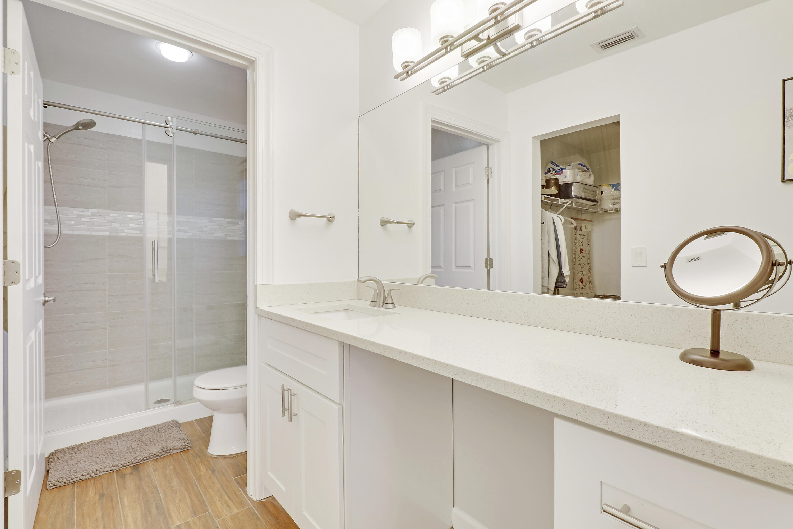 1112 Keystone Drive, Unit A Jupiter, FL 33458 - Photo 21 of 41 a bathroom with a sink a toilet and a large mirror