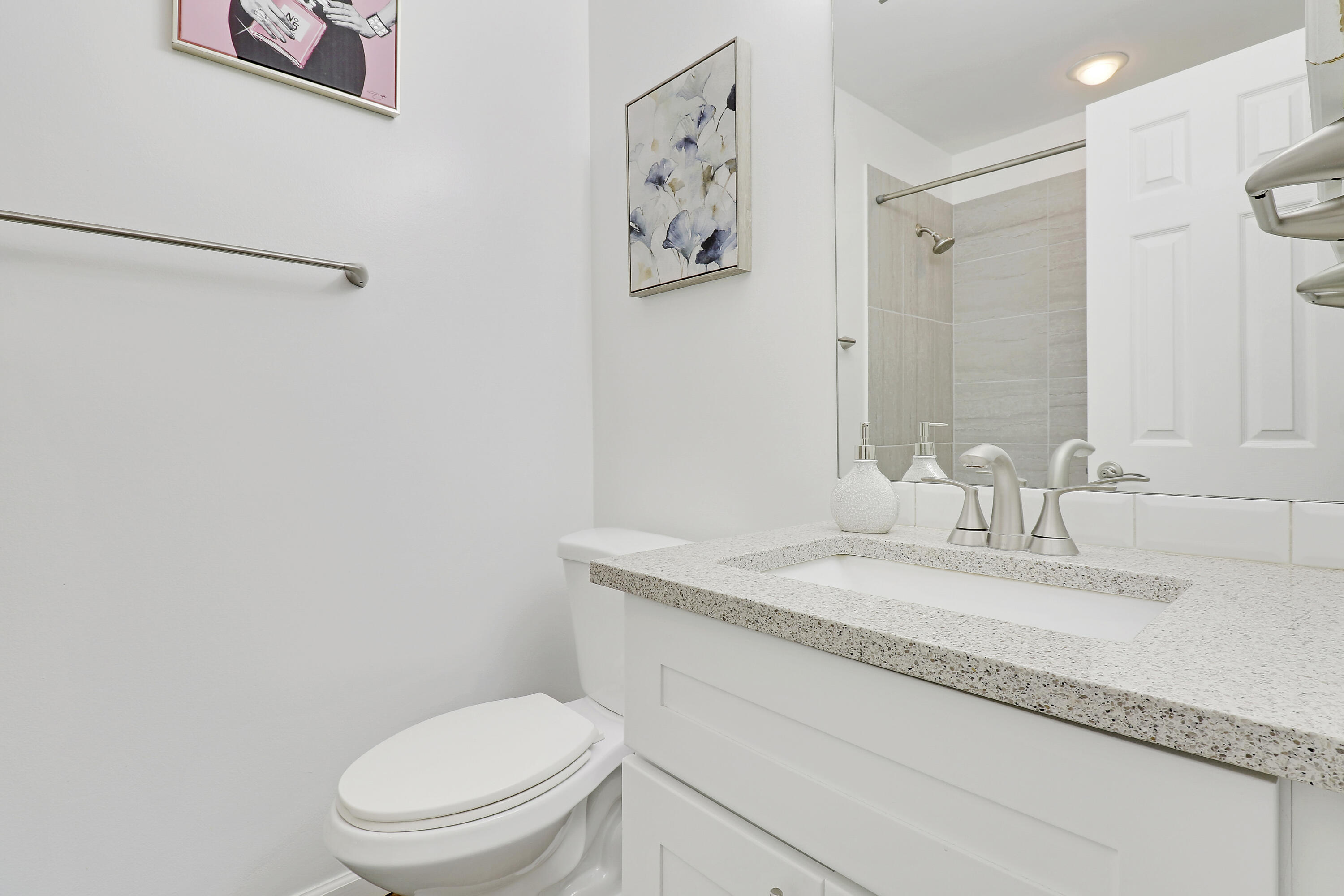 1112 Keystone Drive, Unit A Jupiter, FL 33458 - Photo 24 of 41 a bathroom with a granite countertop toilet sink and mirror