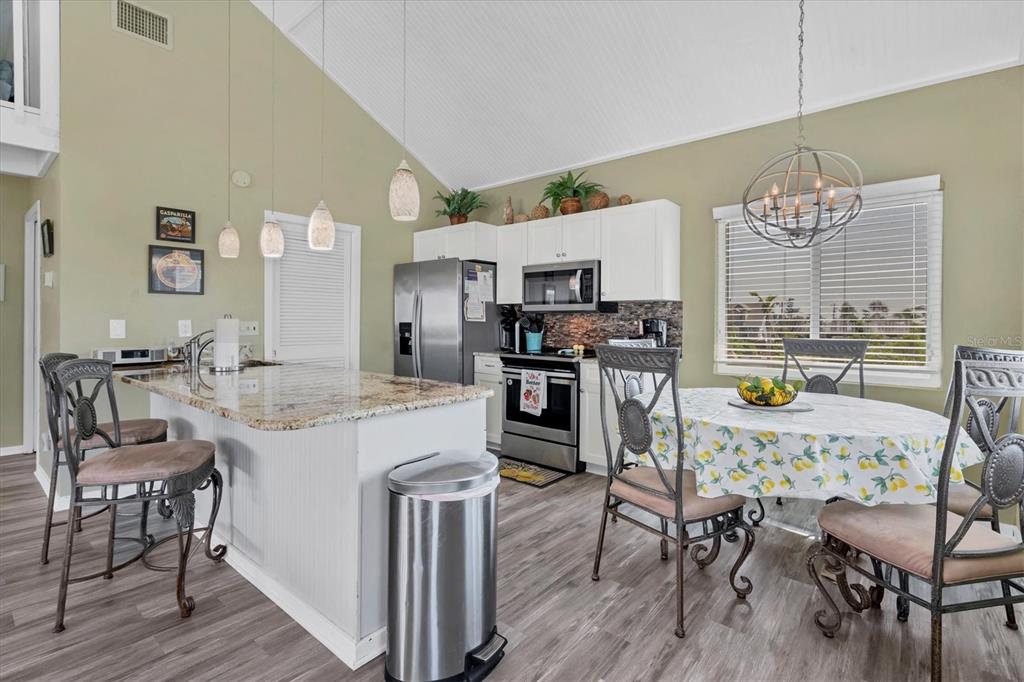 9350 Little Gasparilla Boca Grande, FL 33921 - Photo 25 of 46 a kitchen with stainless steel appliances kitchen island granite countertop a table chairs and a refrigerator