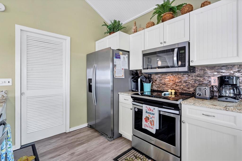 9350 Little Gasparilla Boca Grande, FL 33921 - Photo 26 of 46 a kitchen with granite countertop a stove microwave and refrigerator