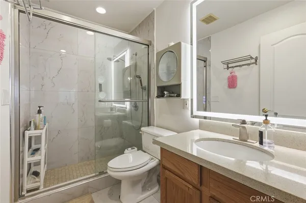 a bathroom with a granite countertop sink toilet and shower