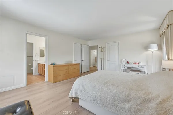 a spacious bedroom with a bed and a cabinets