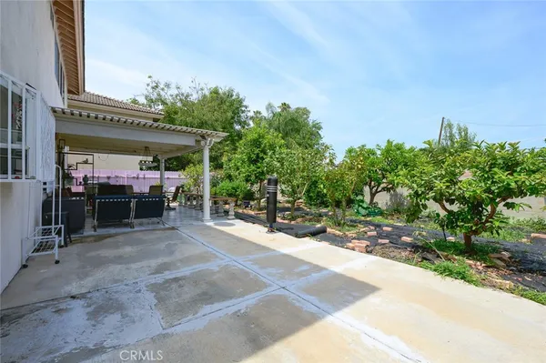 a view of a patio with a table and chairs under an umbrella