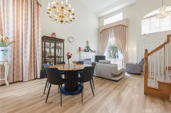a dining room with furniture a chandelier and wooden floor