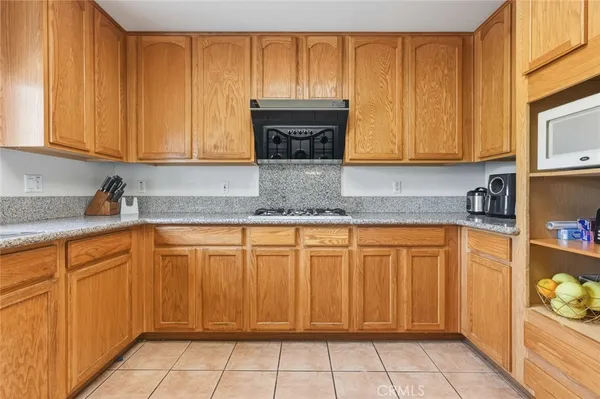 a kitchen with stainless steel appliances granite countertop wooden cabinets a granite counter top and a sink