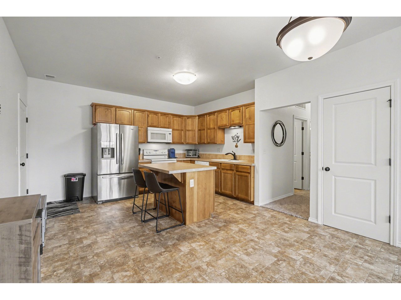 6603 West 3rd Street, Unit 1724 Greeley, CO 80634 - Photo 5 of 23 a kitchen with a refrigerator a sink dishwasher with a dining table and chairs