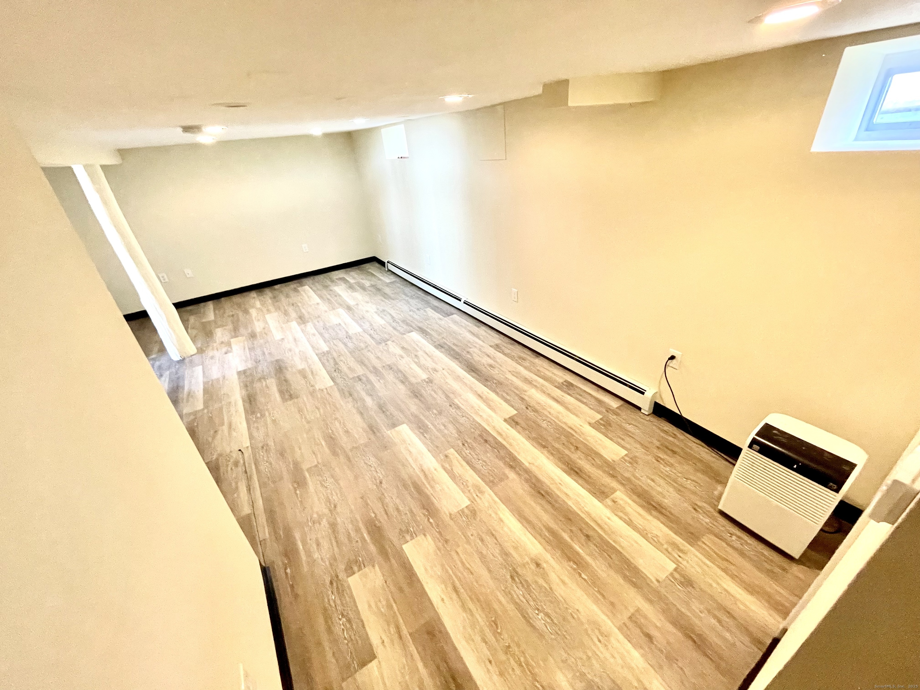 129 Highland Avenue, Unit B Waterbury, CT 06708 - Photo 2 of 17 a view of a big room with wooden floor and windows