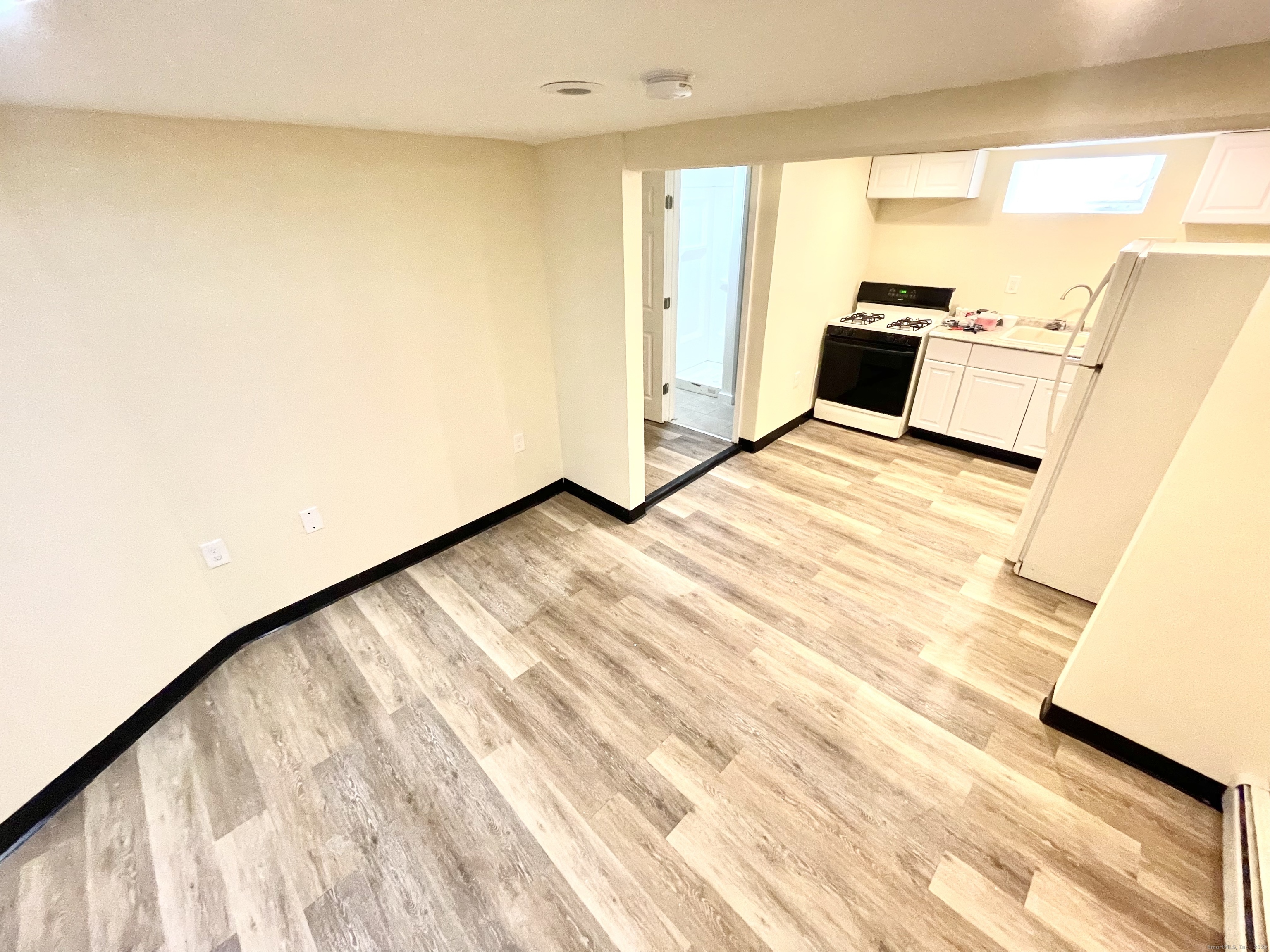 129 Highland Avenue, Unit B Waterbury, CT 06708 - Photo 6 of 17 a view of a kitchen with wooden floor and a sink