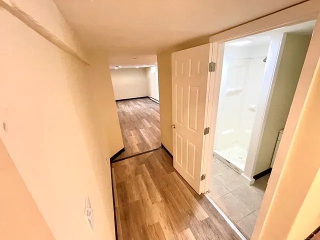 a view of a room with wooden floor and white walls