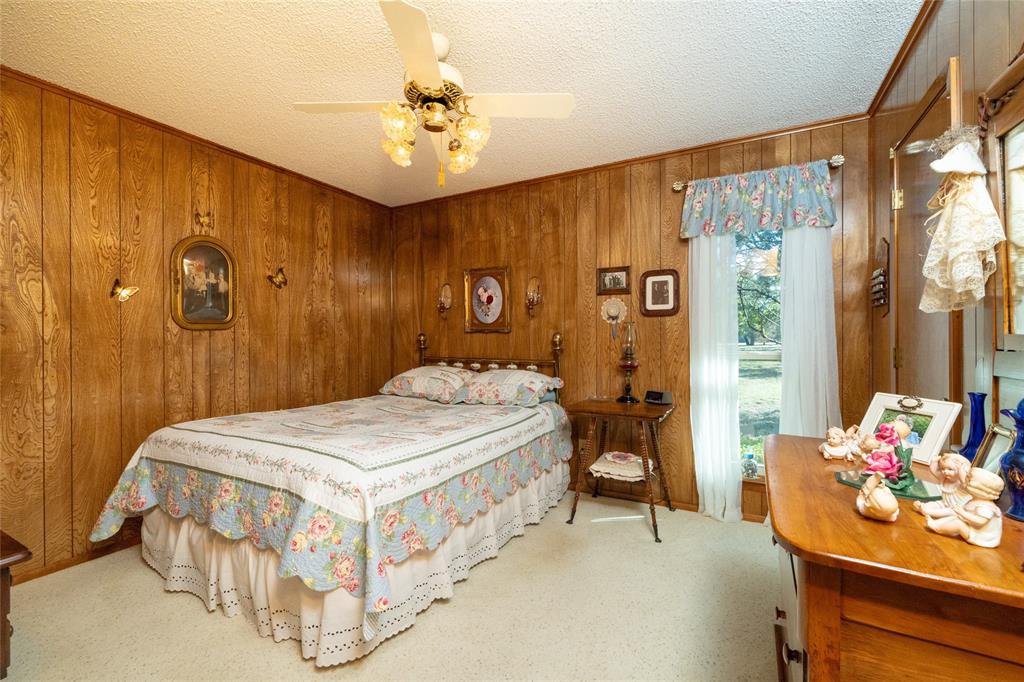 970 Live Oak Road Santo, TX 76472 - Photo 28 of 40 a bedroom with a bed and a chandelier