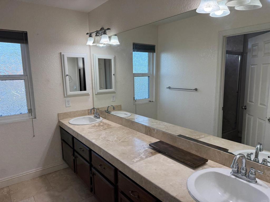 467 Cherry Hills Lane Bonita, CA 91902 - Photo 15 of 42 a bathroom with a granite countertop sink a large mirror and a light fixture
