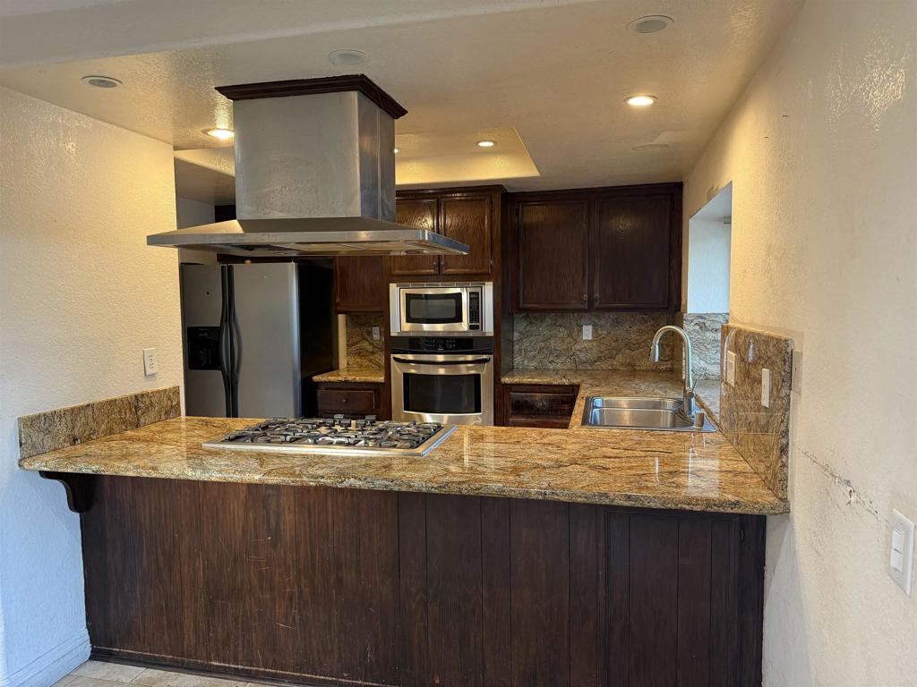 467 Cherry Hills Lane Bonita, CA 91902 - Photo 8 of 42 a kitchen with kitchen island granite countertop a sink cabinets and stainless steel appliances