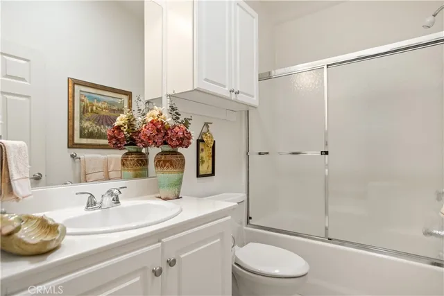 a bathroom with a granite countertop sink toilet a mirror and shower