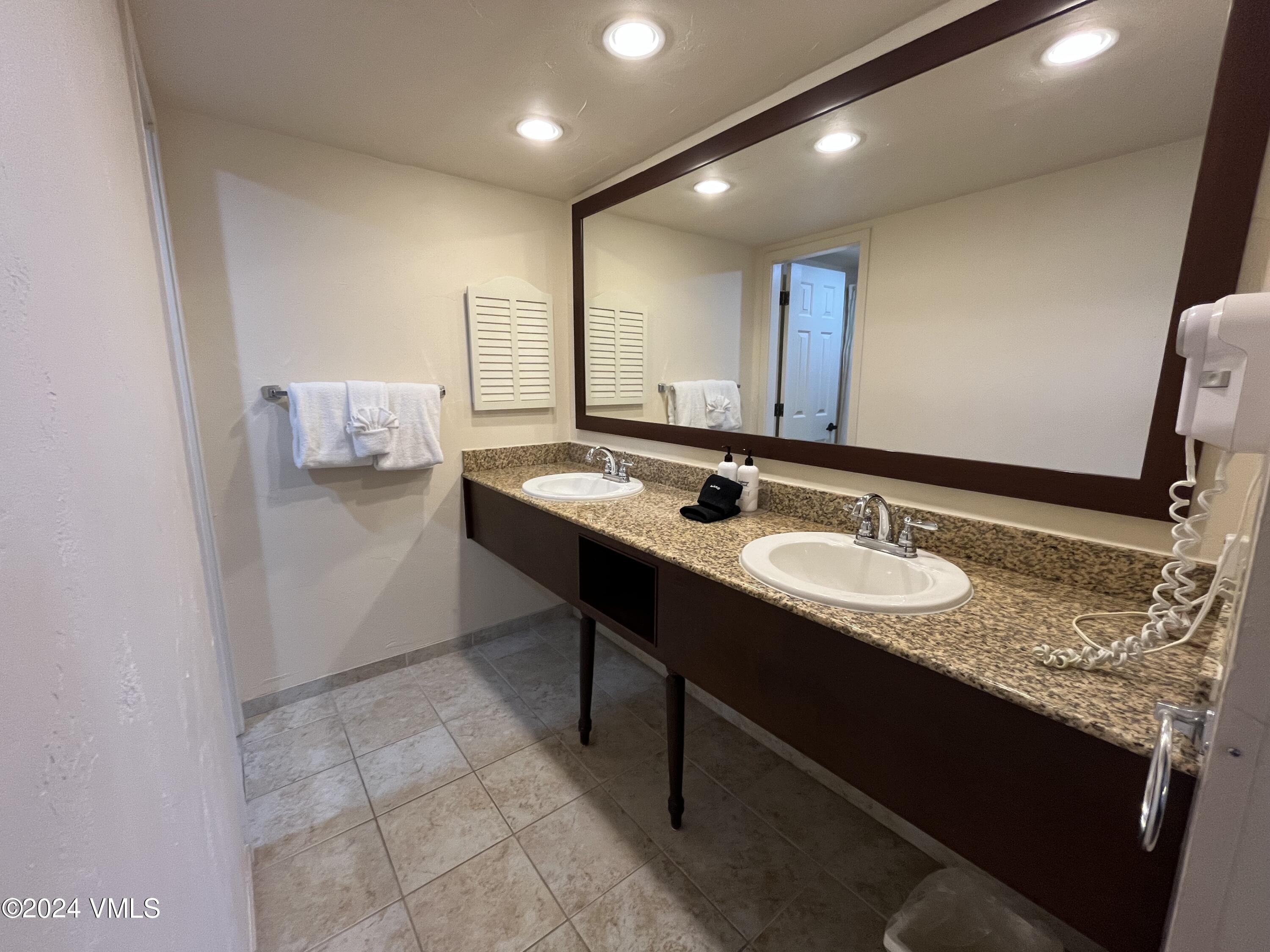 1020 Vail View Drive, Unit 341227 Vail, CO 81657 - Photo 13 of 26 a bathroom with a granite countertop sink and a mirror