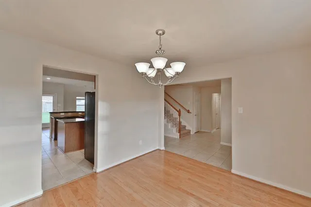 a view of a room with wooden floor and a chandelier