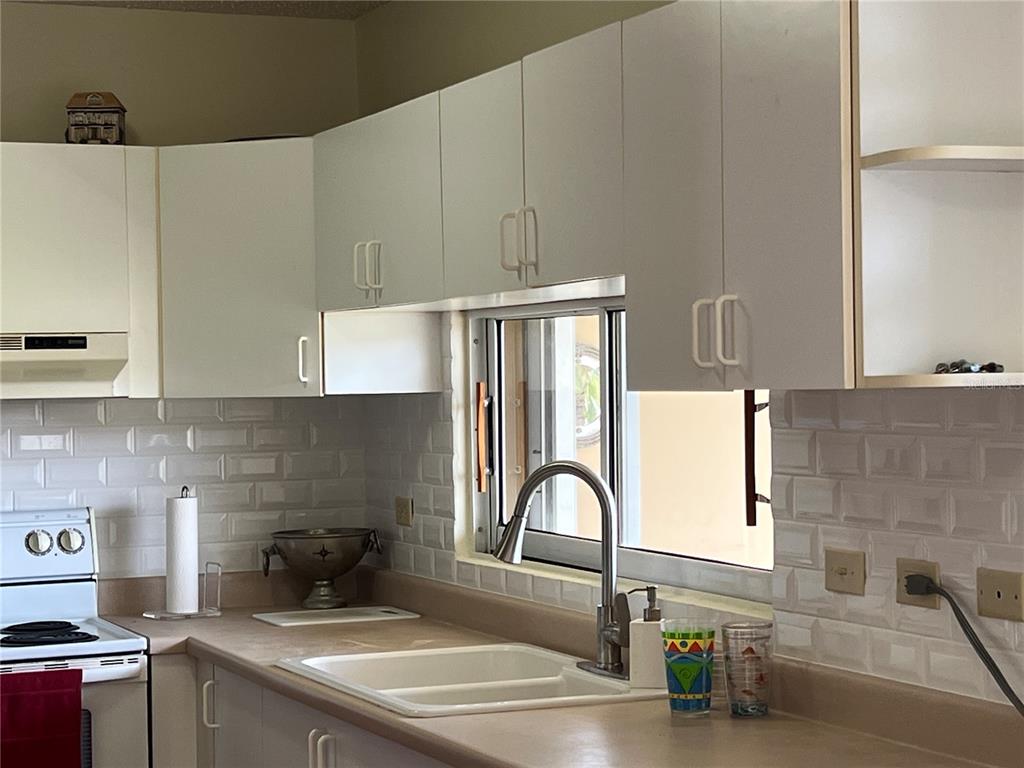 968 Camino Las Picüas, Unit 30 Rio Grande, Río Grande 00745 - Photo 15 of 24 a kitchen with granite countertop a sink a stove and cabinets