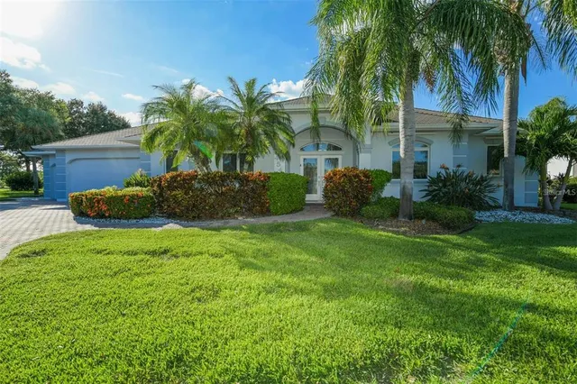 a view of a house with a yard and palm trees