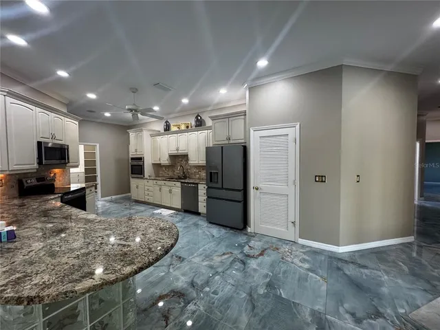 a kitchen with stainless steel appliances kitchen island granite countertop a stove a sink and a microwave