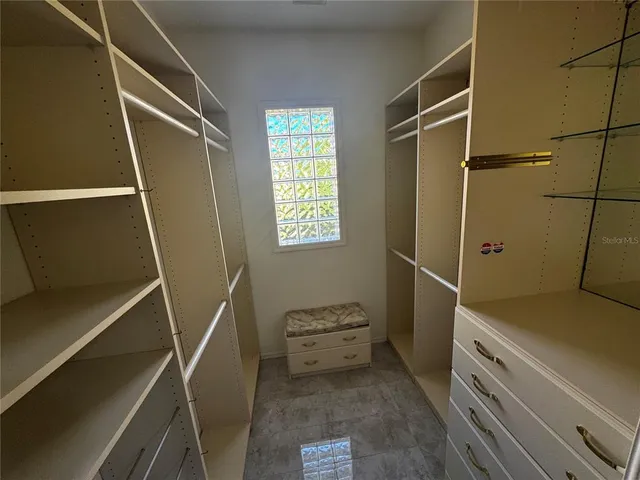a view of walk in closet with empty racks