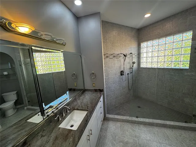 a bathroom with a double vanity sink toilet and shower