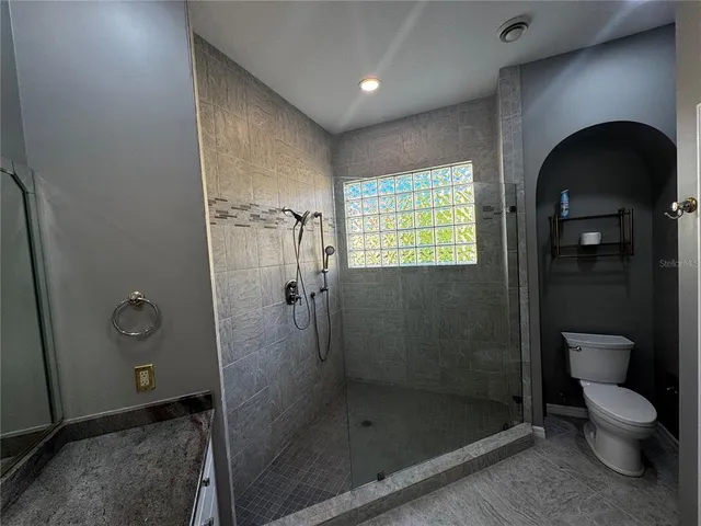 en empty room with windows and ceiling fan