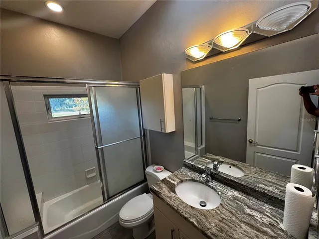 a room with a dresser and chandelier