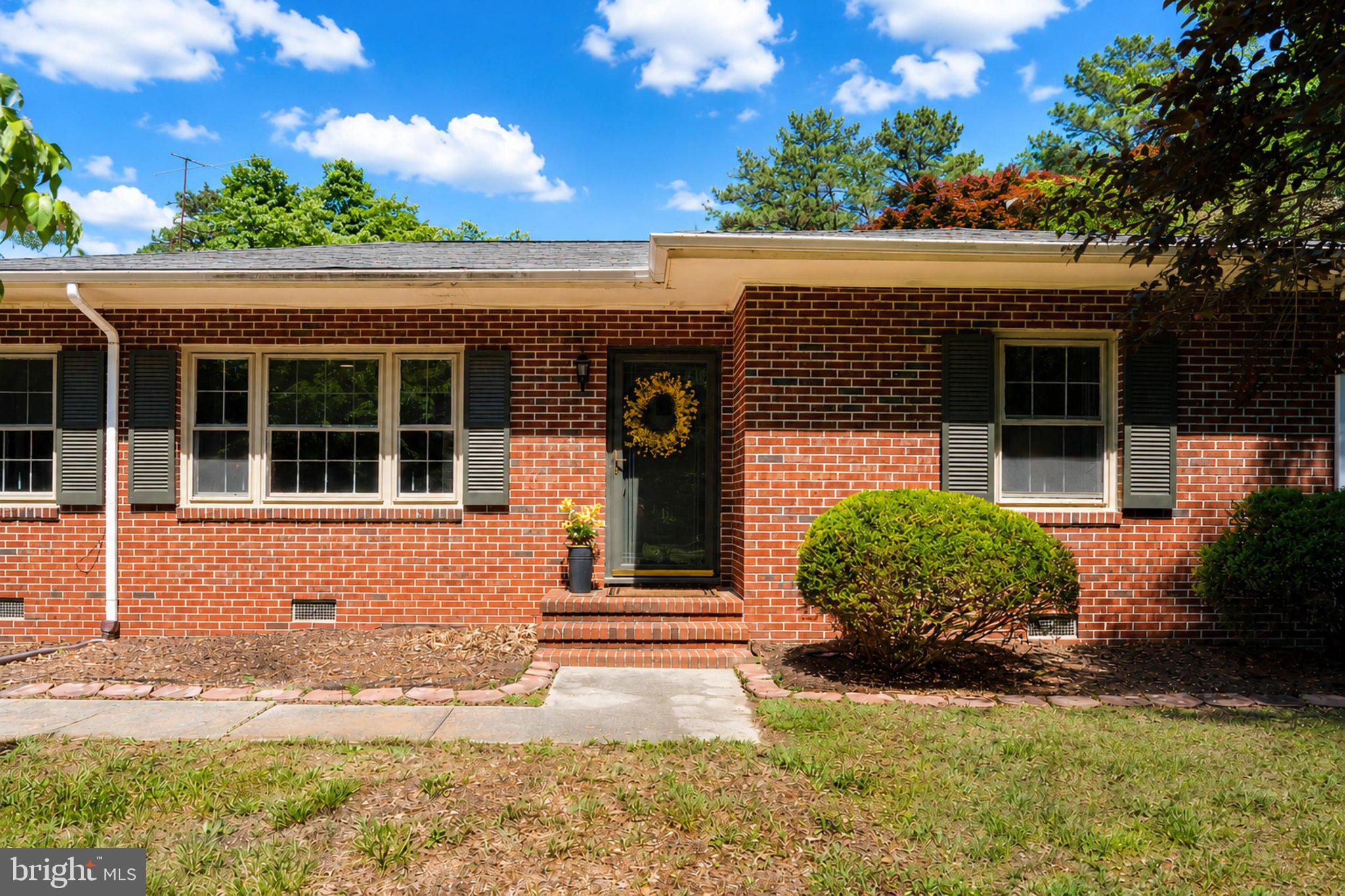 610 Beach Road White Stone, VA 22578 - Photo 2 of 23 Charming brick home with lush greenery.