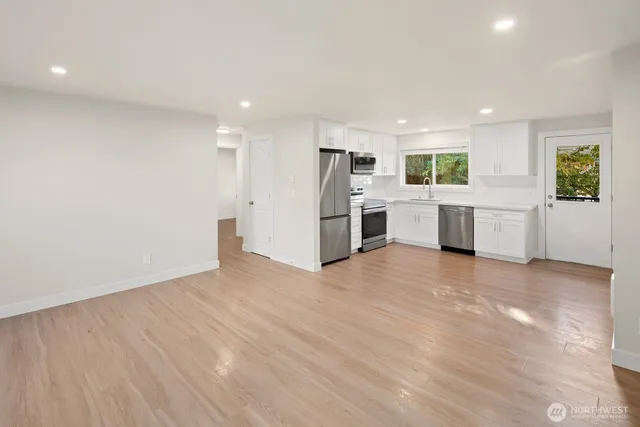 a kitchen with white cabinets and white appliances