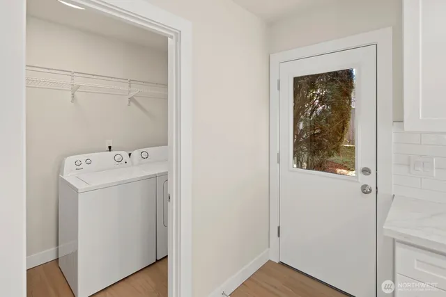 a kitchen with stainless steel appliances granite countertop a dining table chairs refrigerator and sink