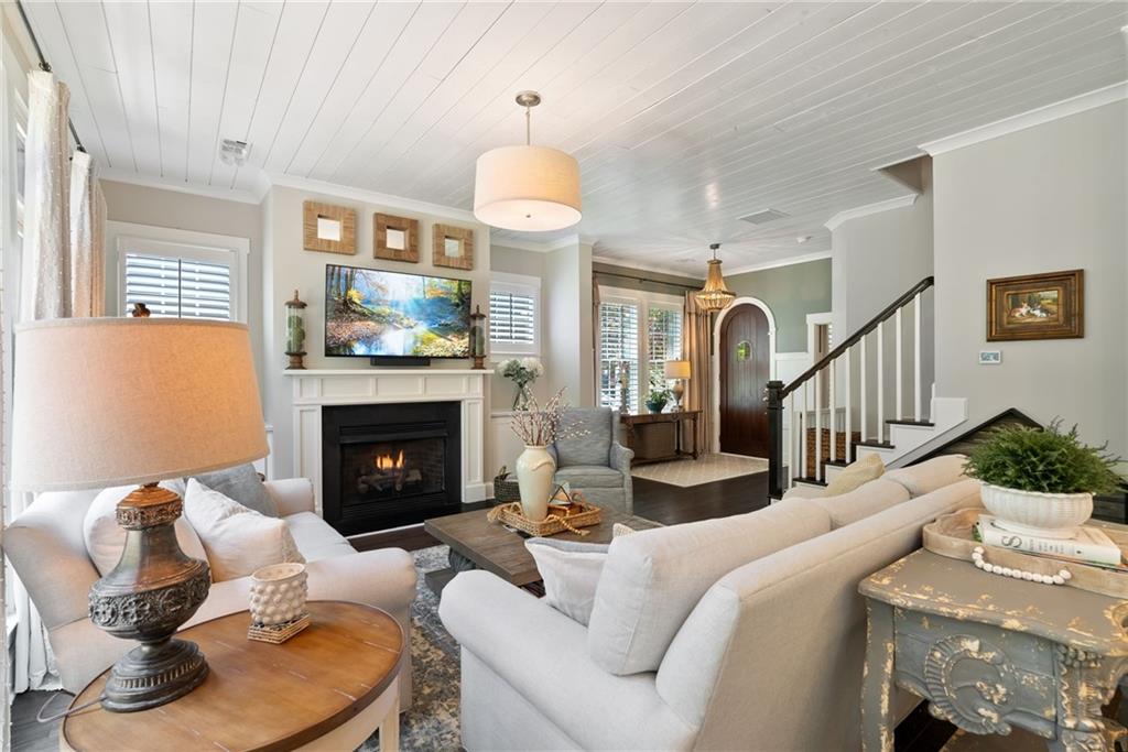 7240 Samples Field Road Cumming, GA 30040 - Photo 14 of 84 a living room with furniture a fireplace and a chandelier