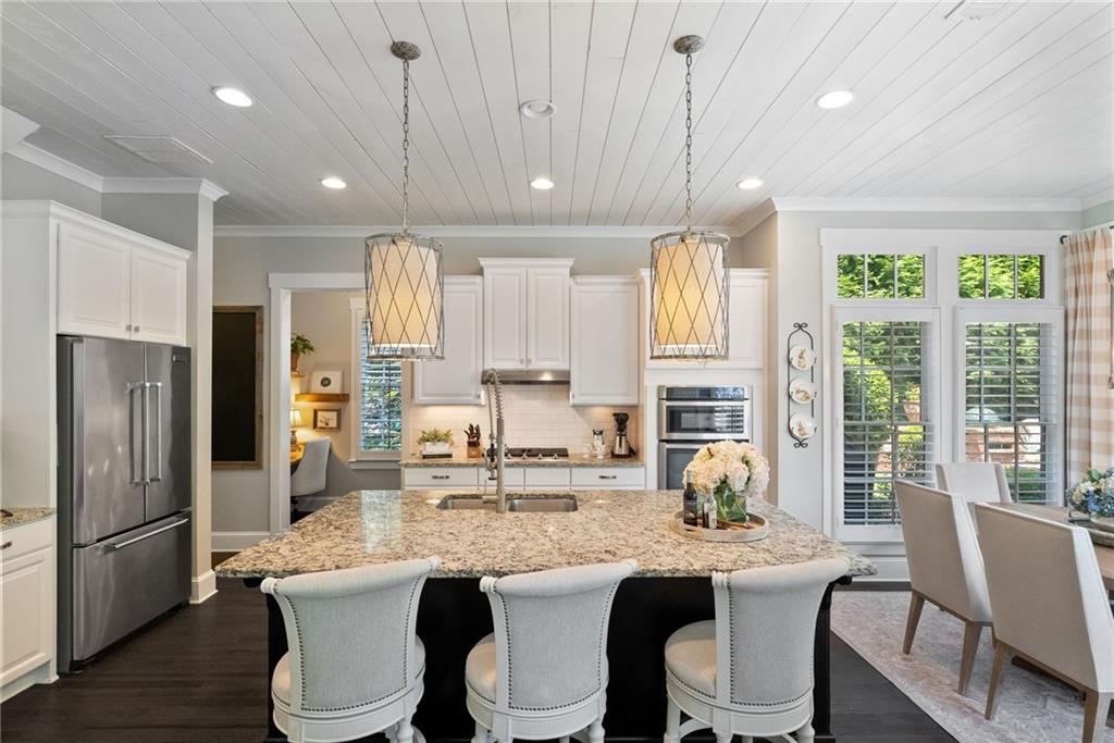 7240 Samples Field Road Cumming, GA 30040 - Photo 17 of 84 a kitchen with stainless steel appliances granite countertop a sink a stove a refrigerator a dining table and chairs