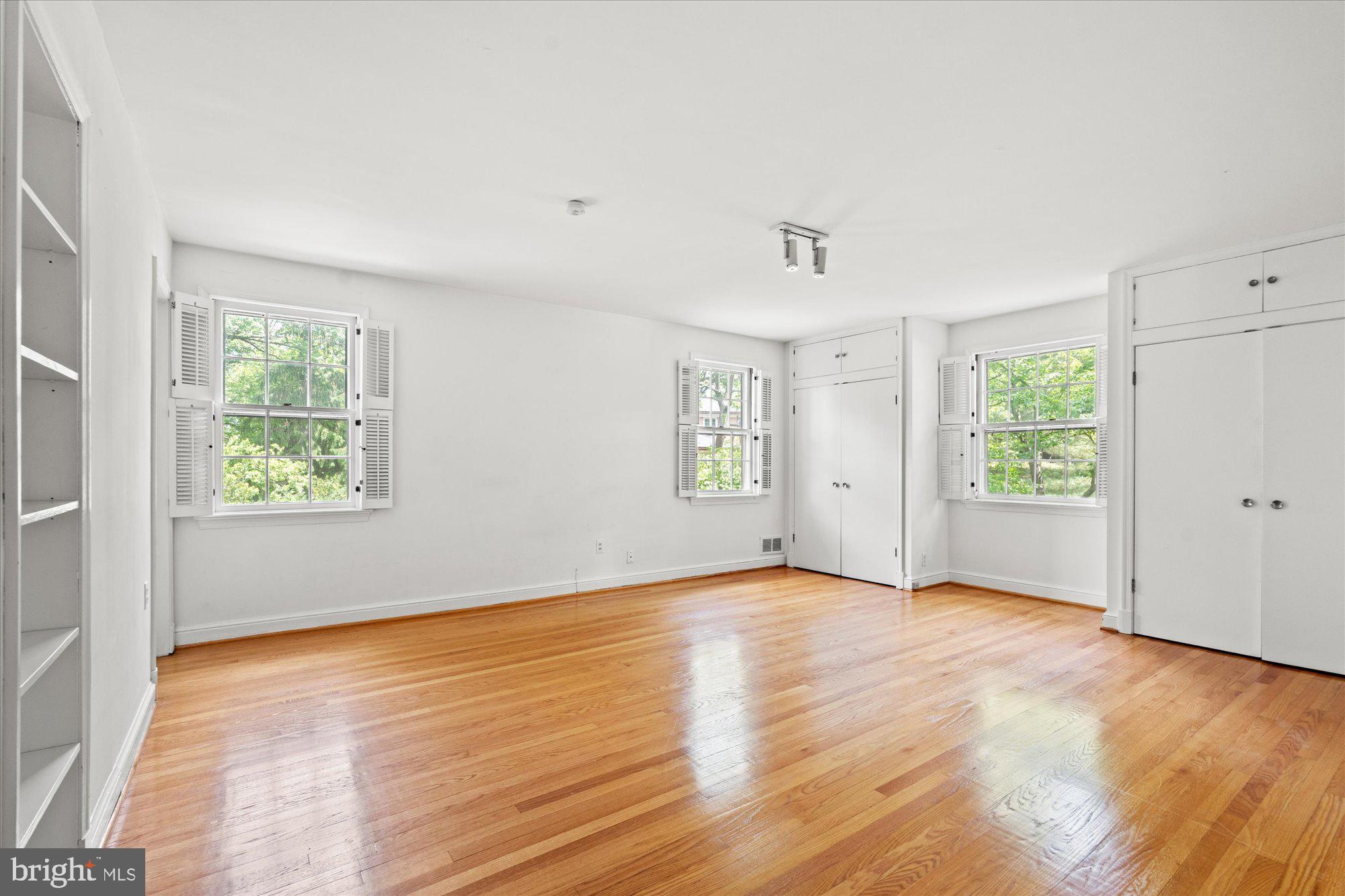 8300 Kerry Road Chevy Chase, MD 20815 - Photo 23 of 42 an empty room with wooden floor and windows