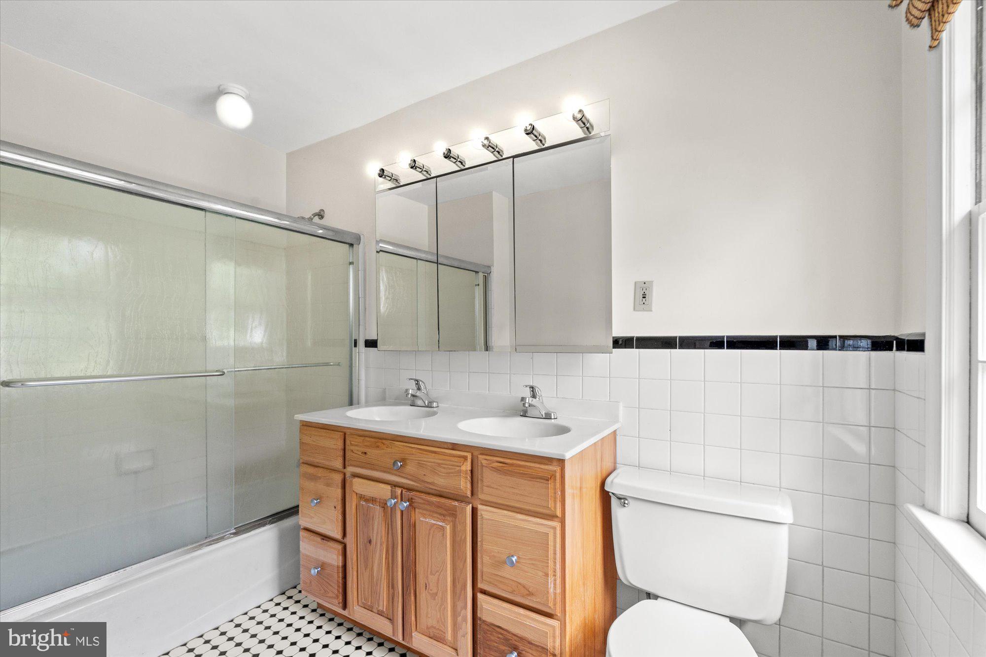 8300 Kerry Road Chevy Chase, MD 20815 - Photo 28 of 42 a bathroom with a sink a toilet a mirror and shower