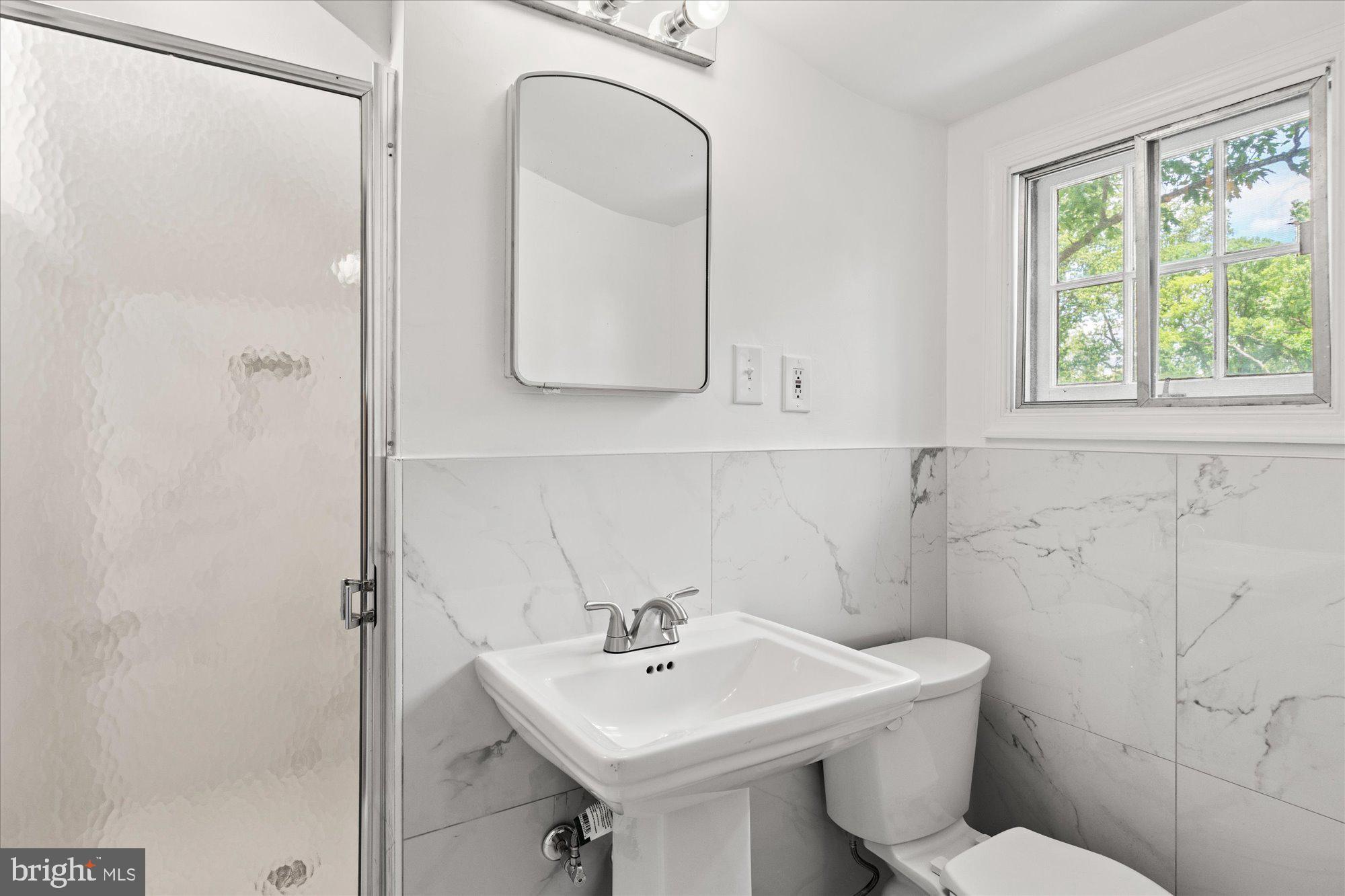 8300 Kerry Road Chevy Chase, MD 20815 - Photo 31 of 42 a bathroom with a toilet a sink and mirror