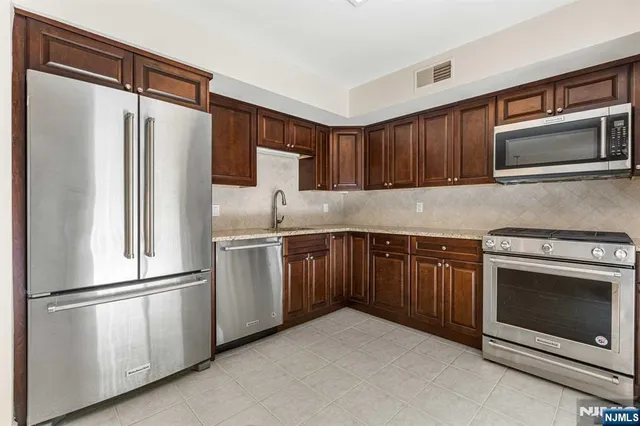a kitchen with granite countertop stainless steel appliances and cabinets