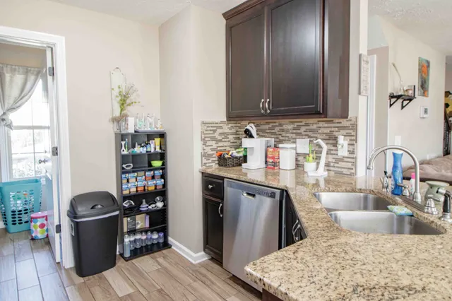 a kitchen with stainless steel appliances granite countertop a sink dishwasher stove and refrigerator