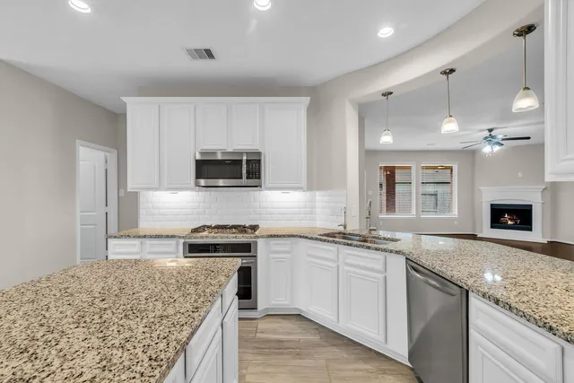 a kitchen with granite countertop kitchen island sink stove and microwave