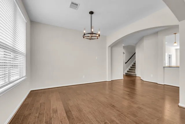 a view of empty room with wooden floor and window