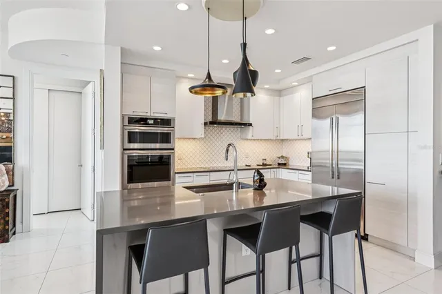 a kitchen with stainless steel appliances granite countertop white cabinets and a stove a oven with white countertops