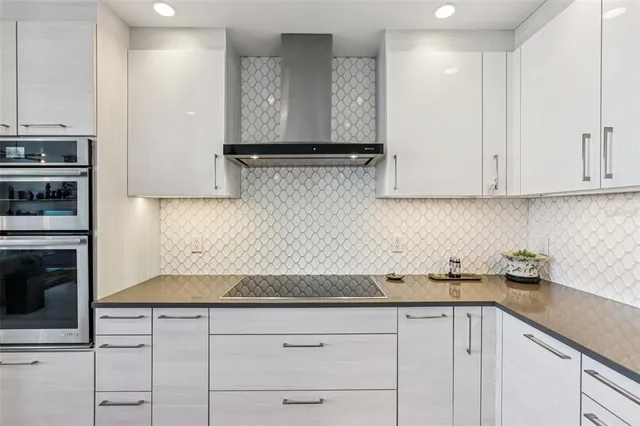 a walk in closet and view of living room