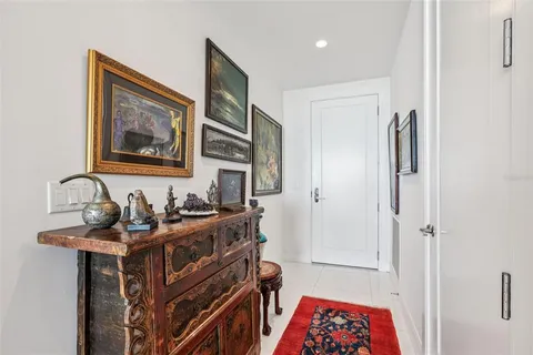 a bedroom with a bed a painting on the wall and a large window