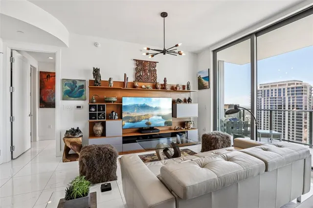 a living room with furniture a chandelier and a dining table